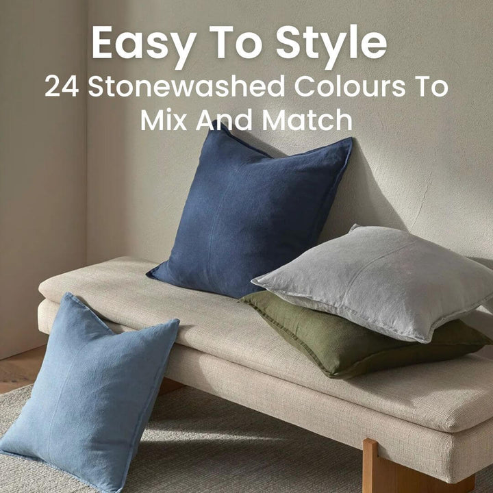Como 50cm and 60cm square linen cushions in stonewashed blue, green and grey on a bench.