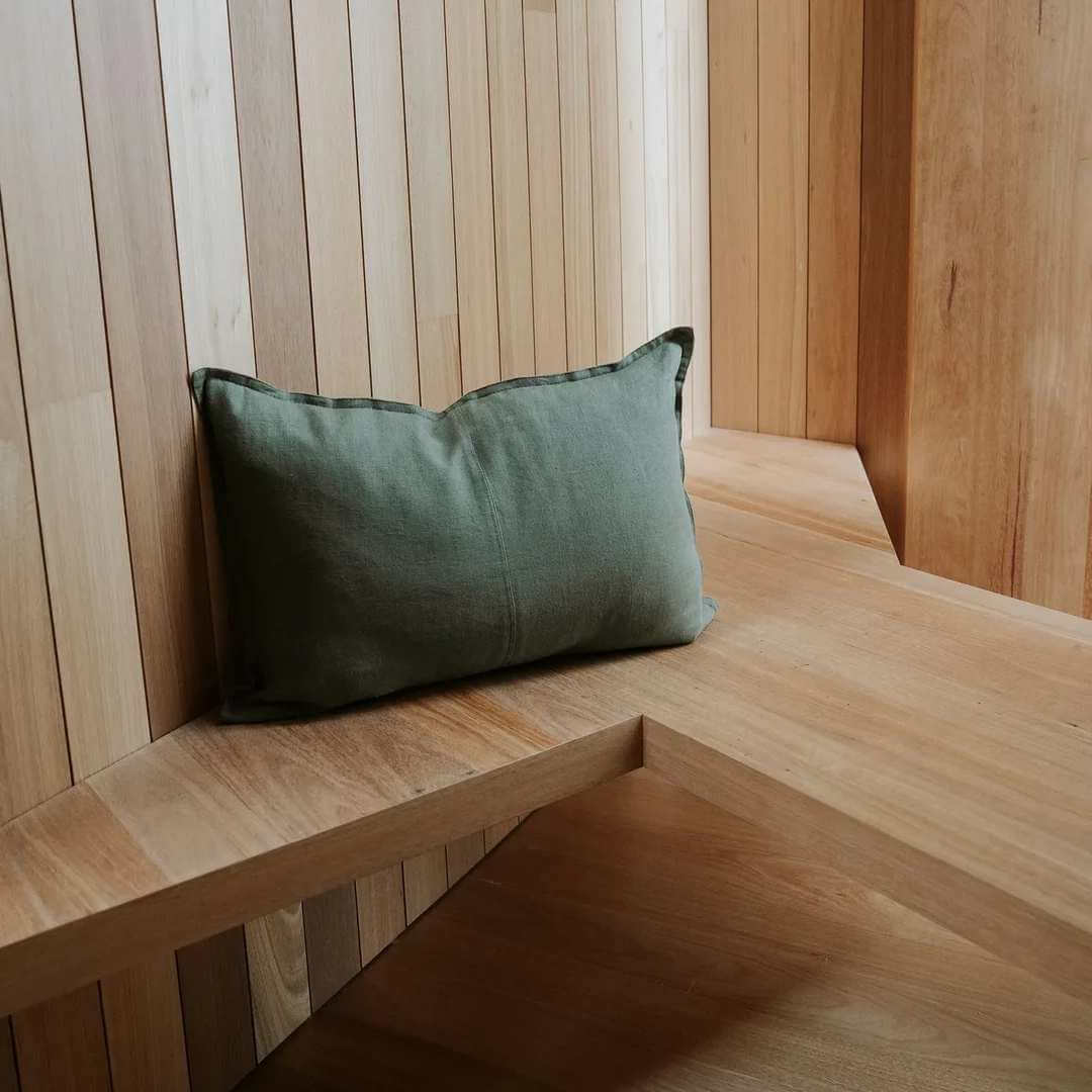 Green rectangle lumbar como linen cushion on a timber bench