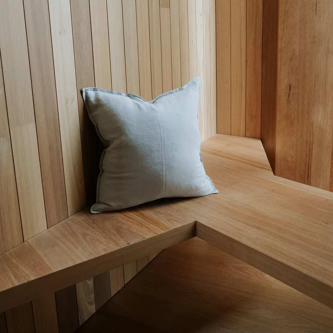 Como 50cm, 60cm Square linen cushion in Haze Light Grey on a bench