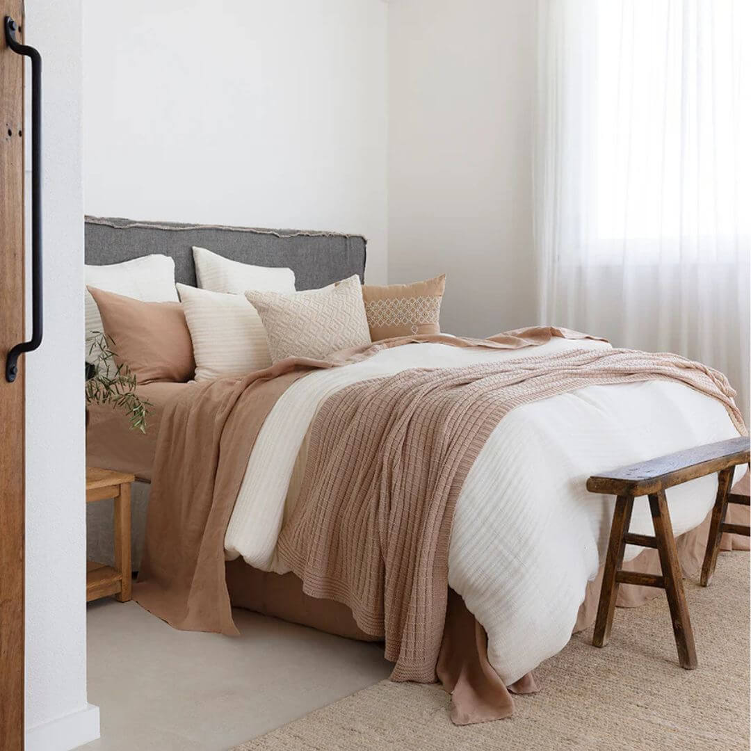 Decorative throws in a variety of sizes, including extra large, styled on a bed with cushions — Beautiful Home Decor