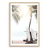A wall art print of two white surf boards under the palm trees on a surfer beach in Hawaii in a timber frame with a white border