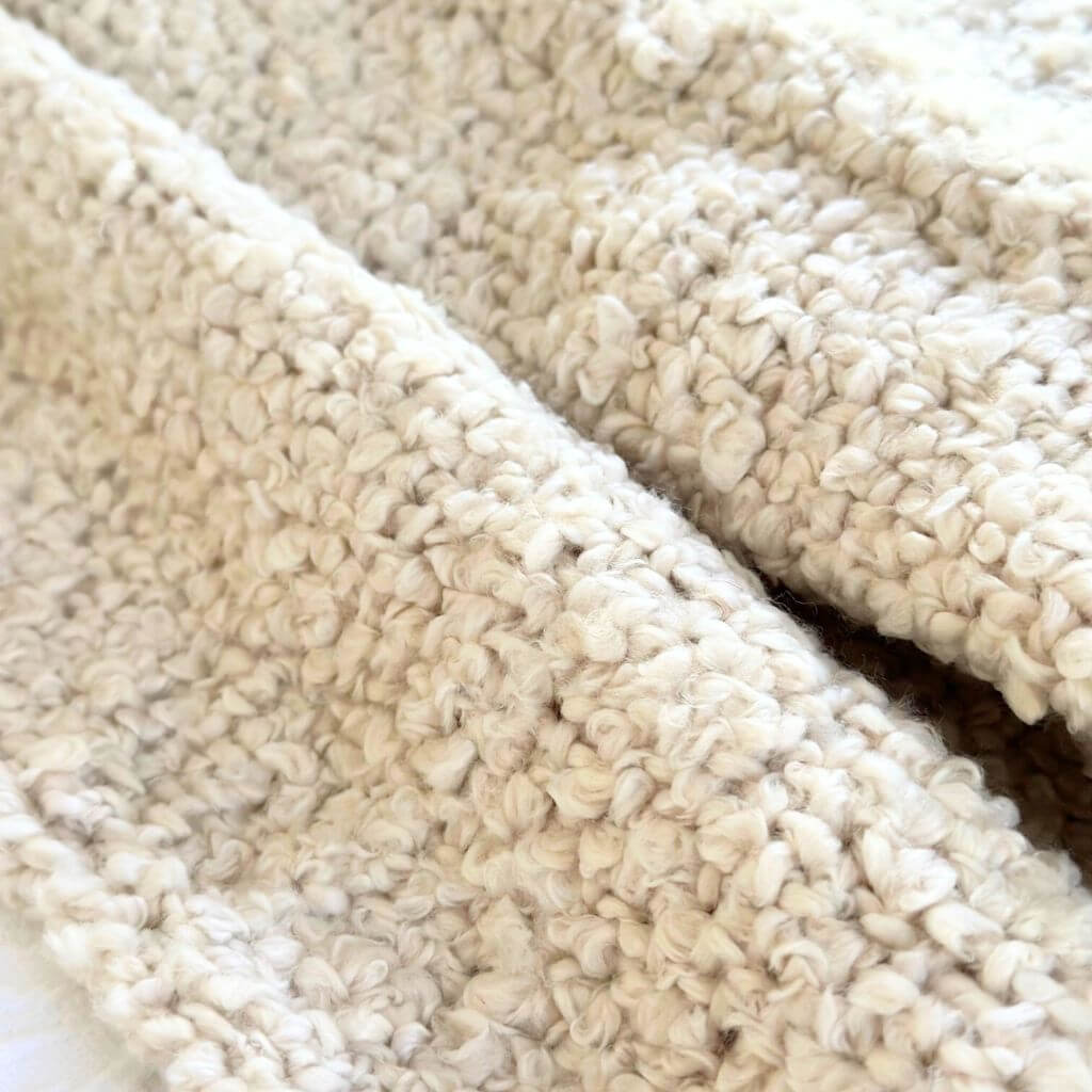 A gorgeous, soft, cream Jade Throw with a boucle design, measuring 130cm x 160cm to decorate your bed or sofa.