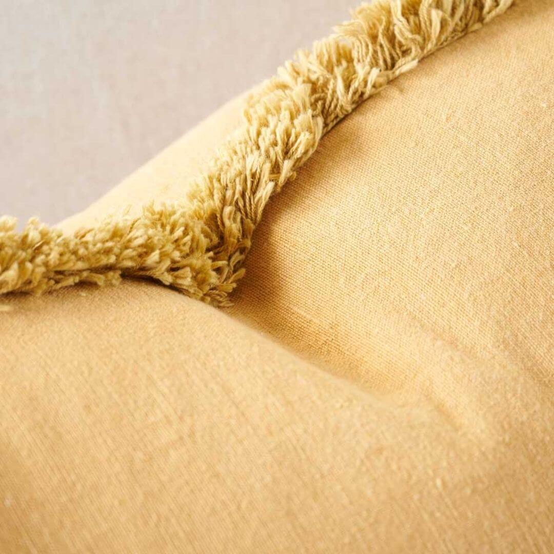 A close up of the Turmeric Yellow Square 50cm Luca Boho Fringe Cushion