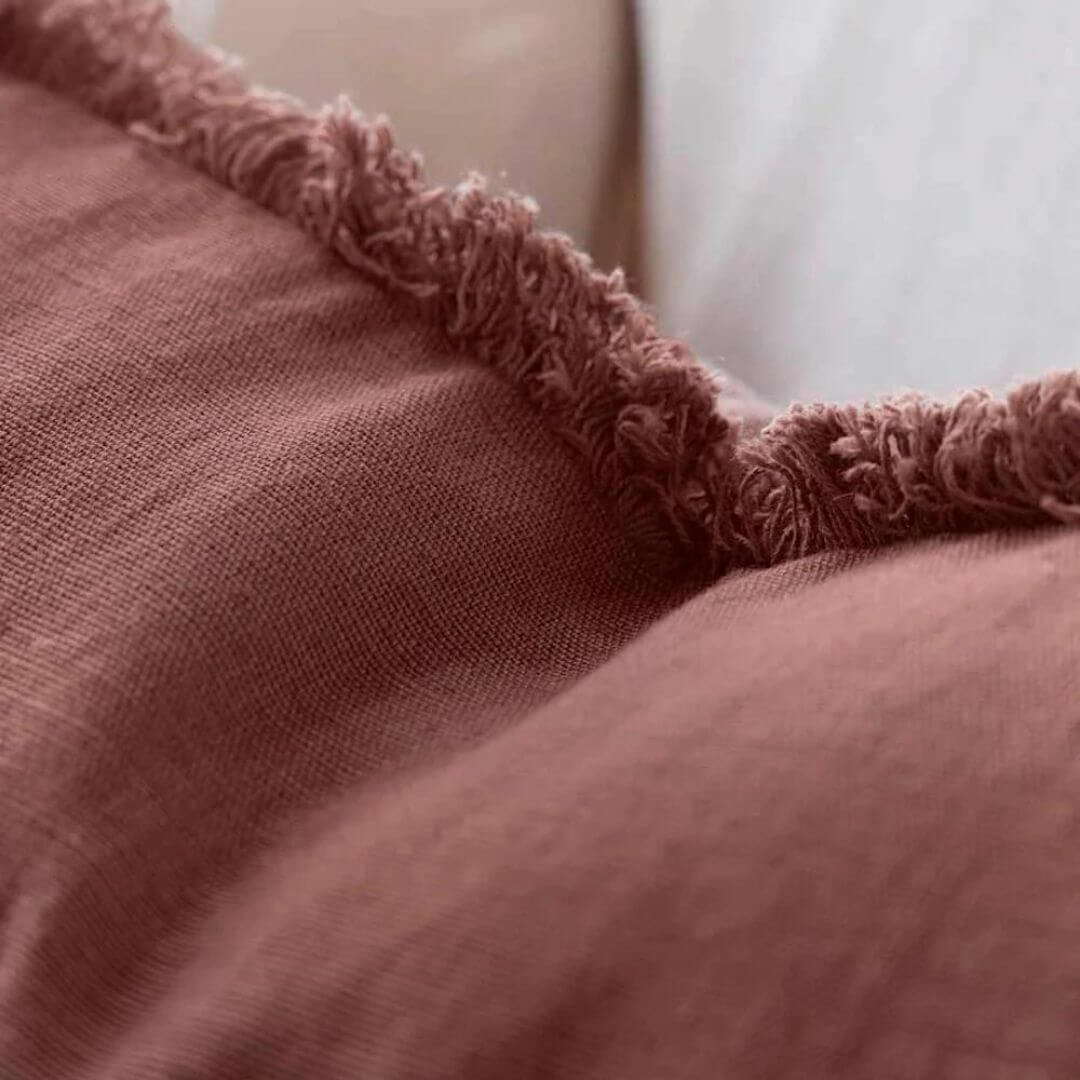 The Cotton fringe edge of a desert rose red cushion part of Square 60cm Luca Boho Fringe Linen Cushion and throw bundle set