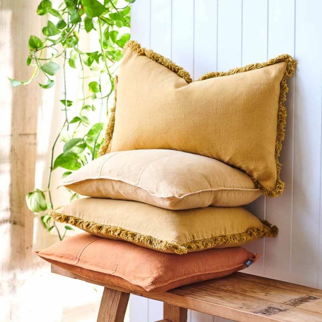 Decorate the Turmeric Yellow Square 60cm Luca Boho Fringe Cushion alongside cushions in similar warm colours.