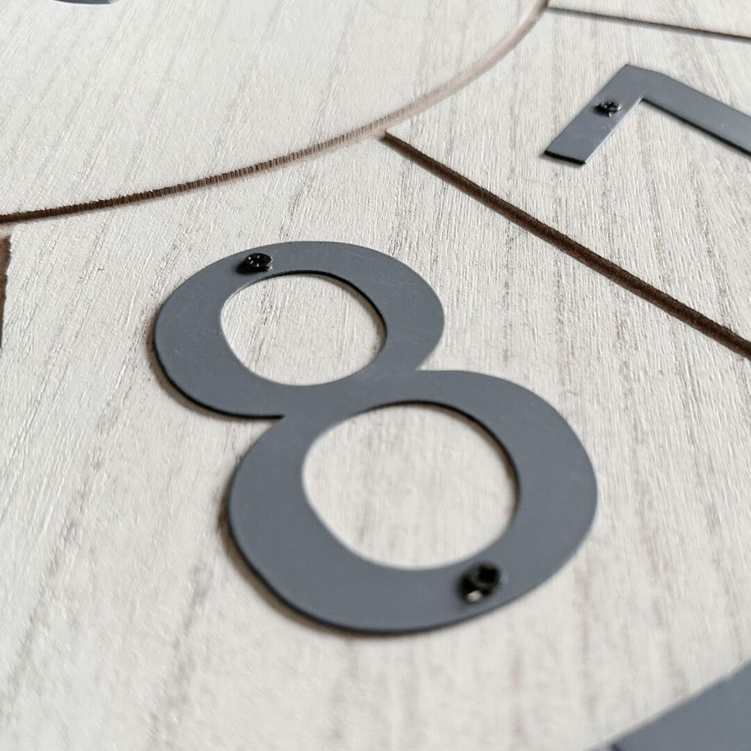 A close-up view of the metal numbers on the 60cm Scandi White Wall Clock.