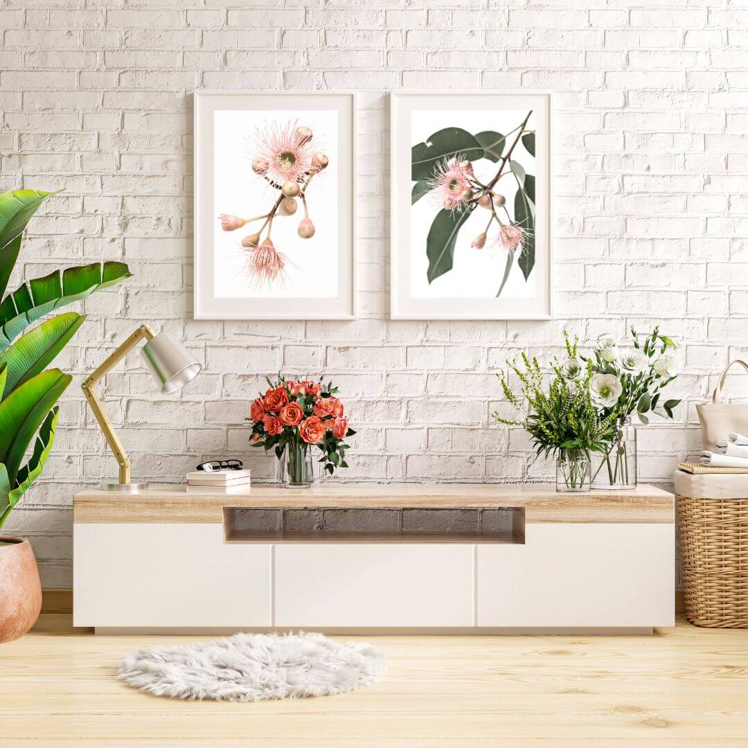 A wall art set of prints featuring pink eucalyptus wild flowers with green leaves with a  neutral background. 