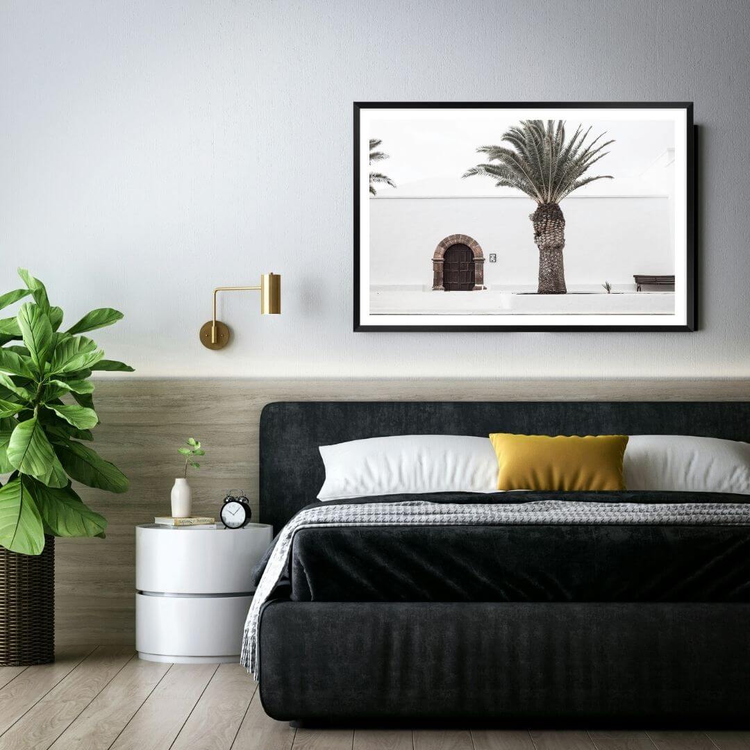 A wall art photo print of a white Spanish Church with a Palm Tree  with a black frame or unframed for a wall above your bedroom bed