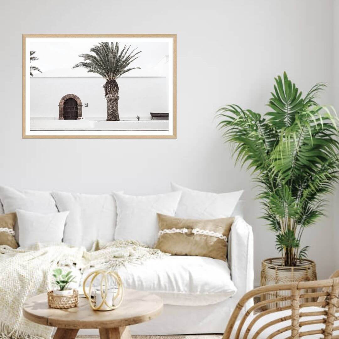 A wall art photo print of a white Spanish Church with a Palm Tree  with a timber frame or unframed for your coastal living room behind sofa