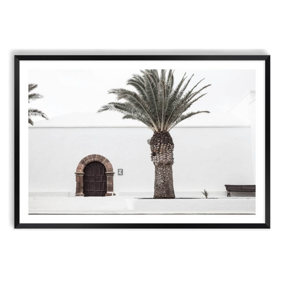 A wall art photo print of a white Spanish Church with a Palm Tree  with a black frame, white border by Beautiful Home Decor