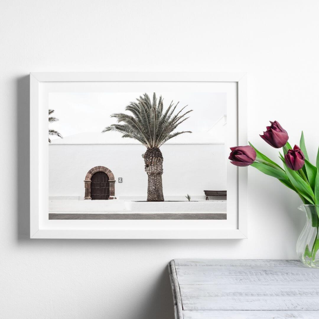 A wall art photo print of a white Spanish Church with a Palm Tree  with a white frame or unframed to style shelves and empty walls