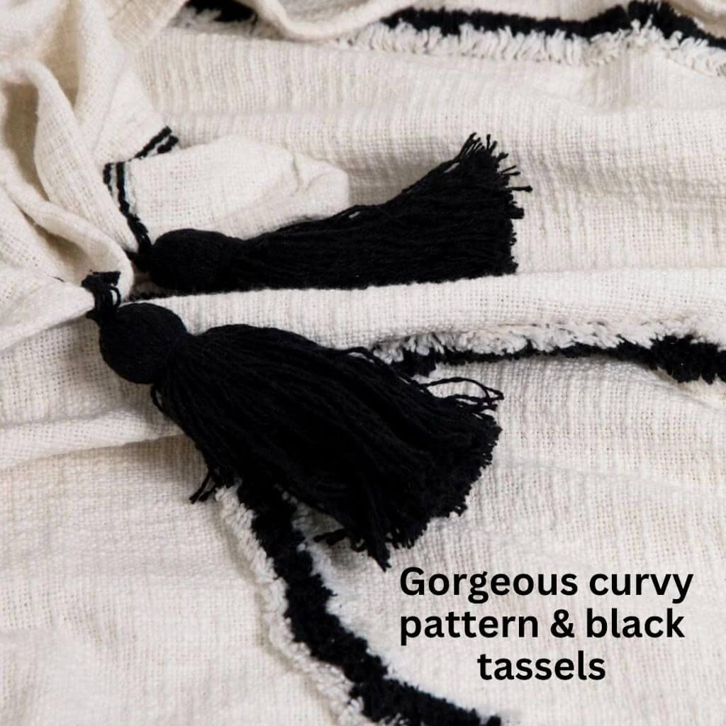 The Black and Ivory White Waverley Throw with black tassels and a curvy pattern, measures 130cm x 160cm, the perfect throw to style your bed or sofa.
