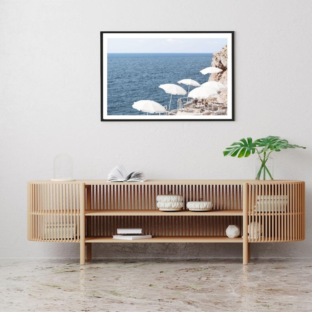 A wall art photo print of white umbrellas on an Amalffi Coast Beach Italy with a black frame or unframed to decorate a wall above your console table