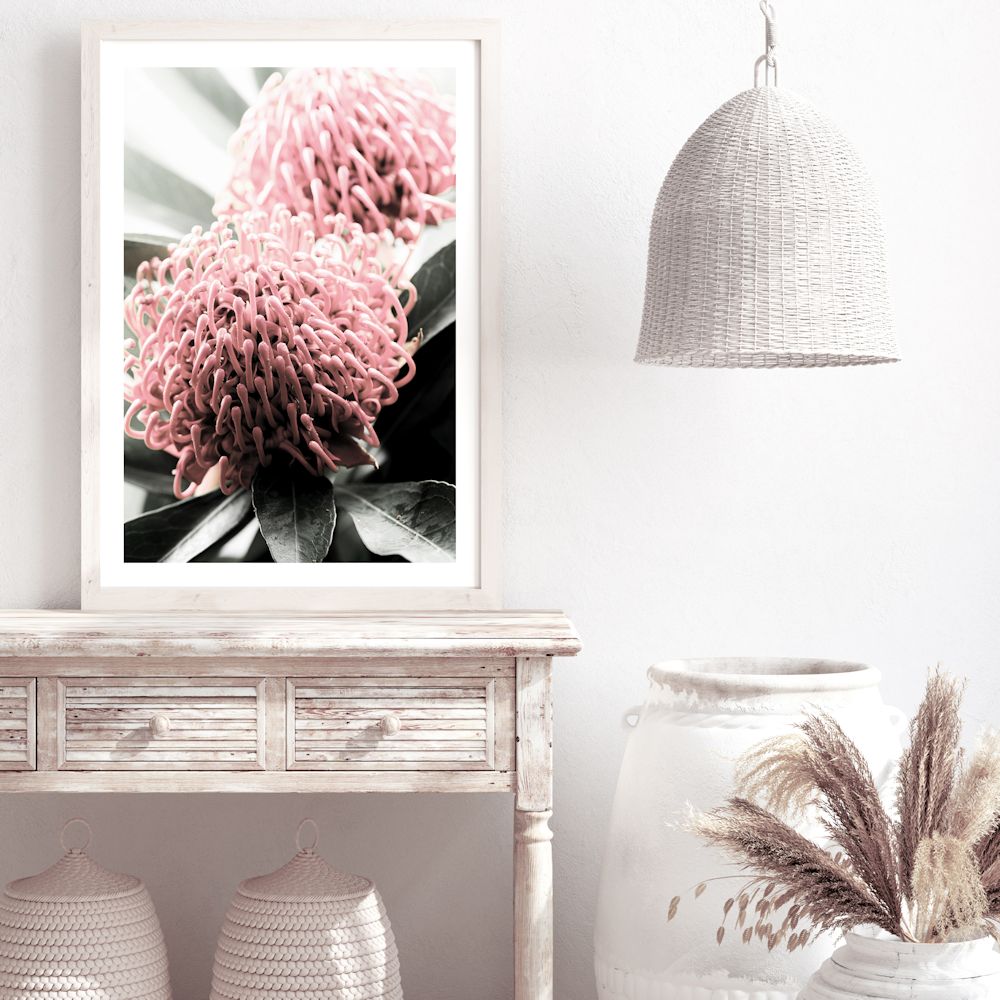 A beautiful floral wall art of two red Australian native Waratah flowers with muted green leaves in the background, available unframed or framed.