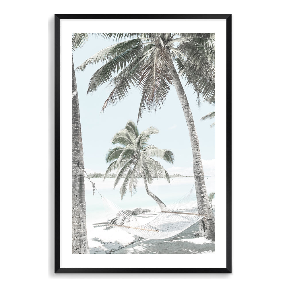 A photographic artwork of a hammock between two palm trees on a tropical beach, available in canvas or print, framed or unframed.
