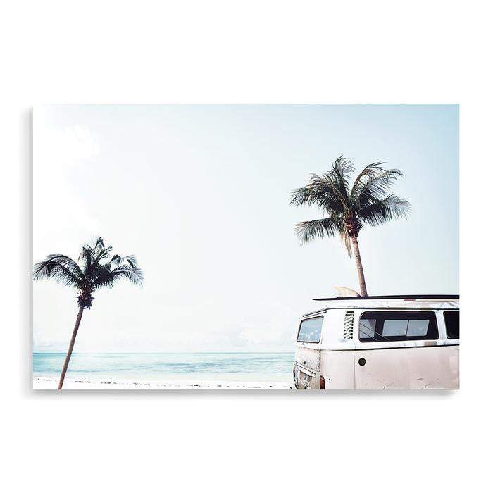 A canvas wall art print featuring an iconic blue Kombi van at the beach with palm trees, available in framed or unframed prints.