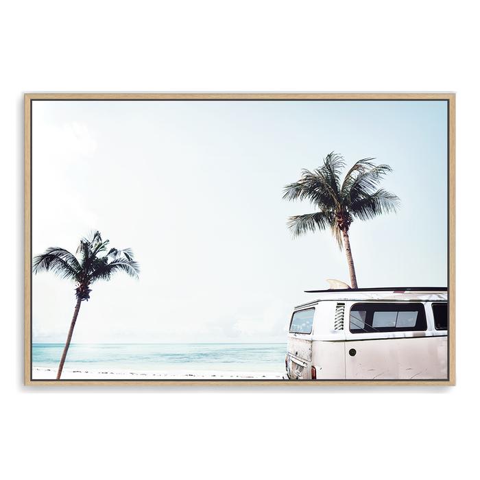 A stretched canvas print of an iconic blue Kombi van at the beach with palm trees, available framed or unframed of a beachside kombi van.