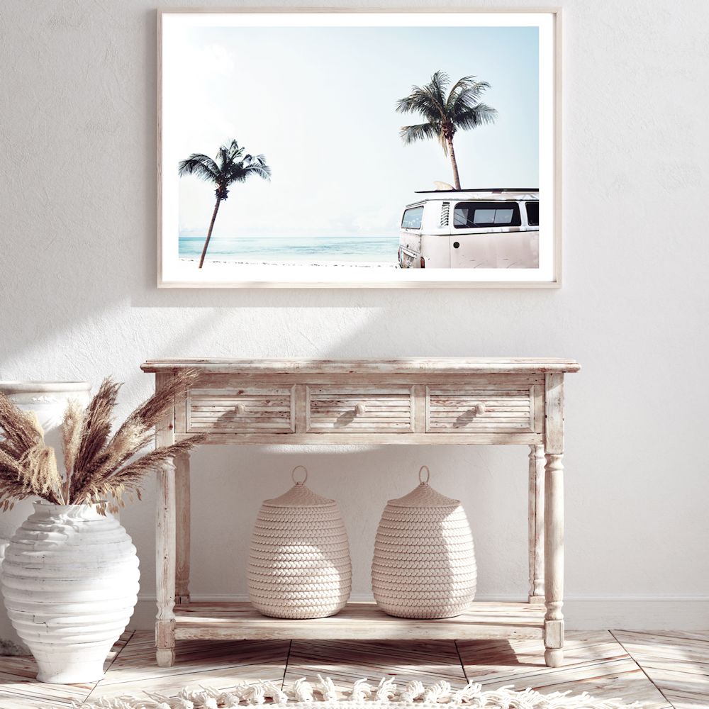 An iconic blue Kombi van at the beach with palm trees available in a canvas or photo wall art print.