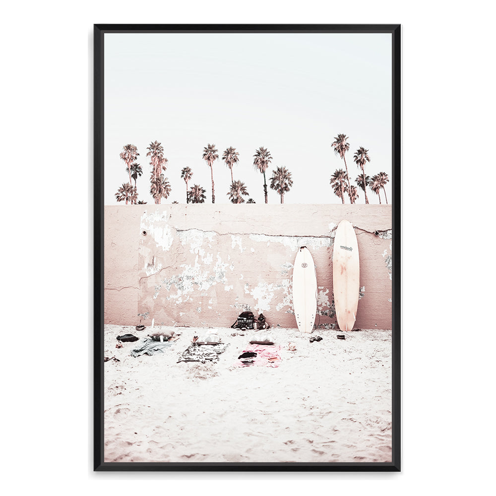Featuring surf boards on the beach with palm trees and a wall, this artwork is available unframed or framed with a timber, black or white frame.
