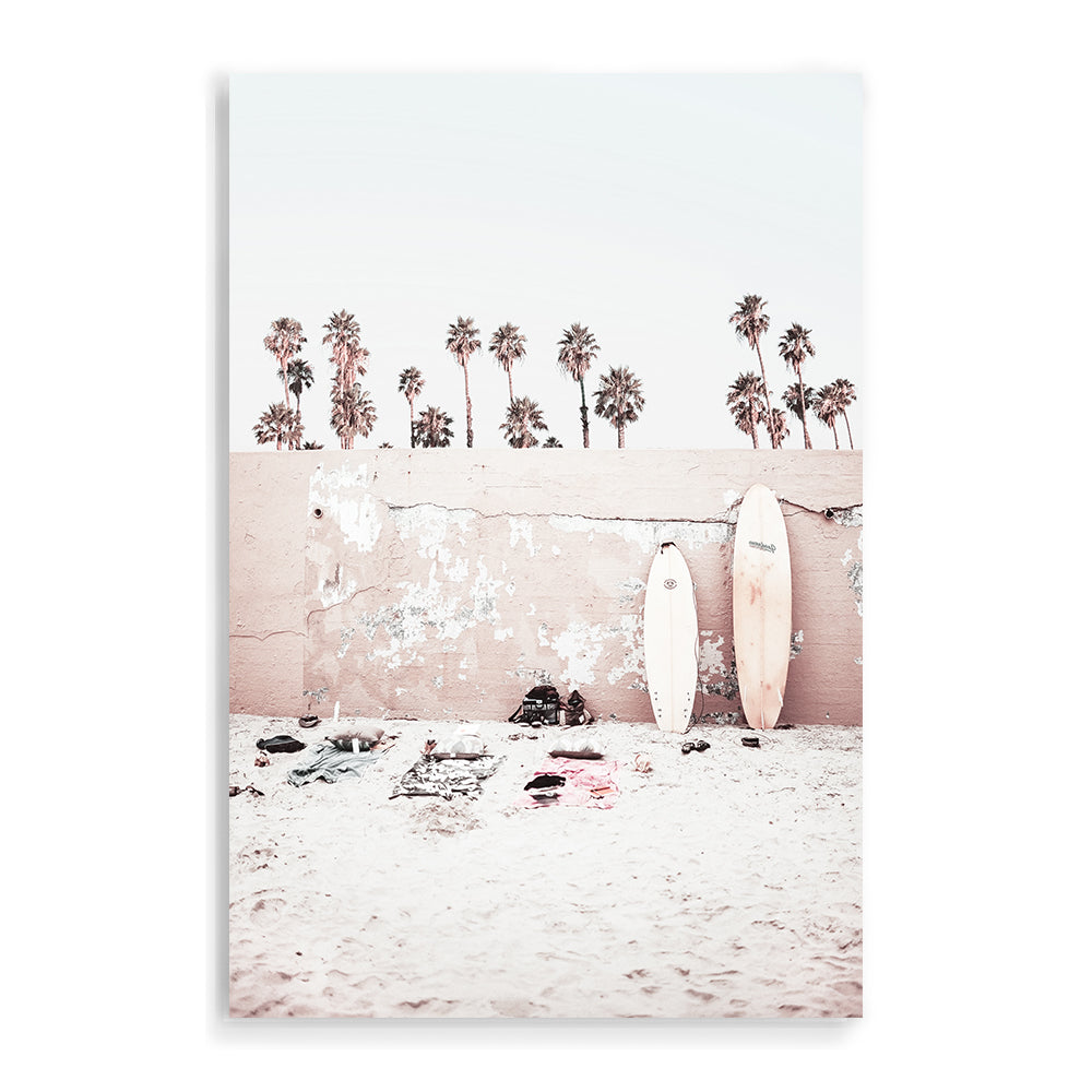 Featuring surf boards on the beach with palm trees and a wall, this wall art print is available framed with a timber, black or white frame or unframed.