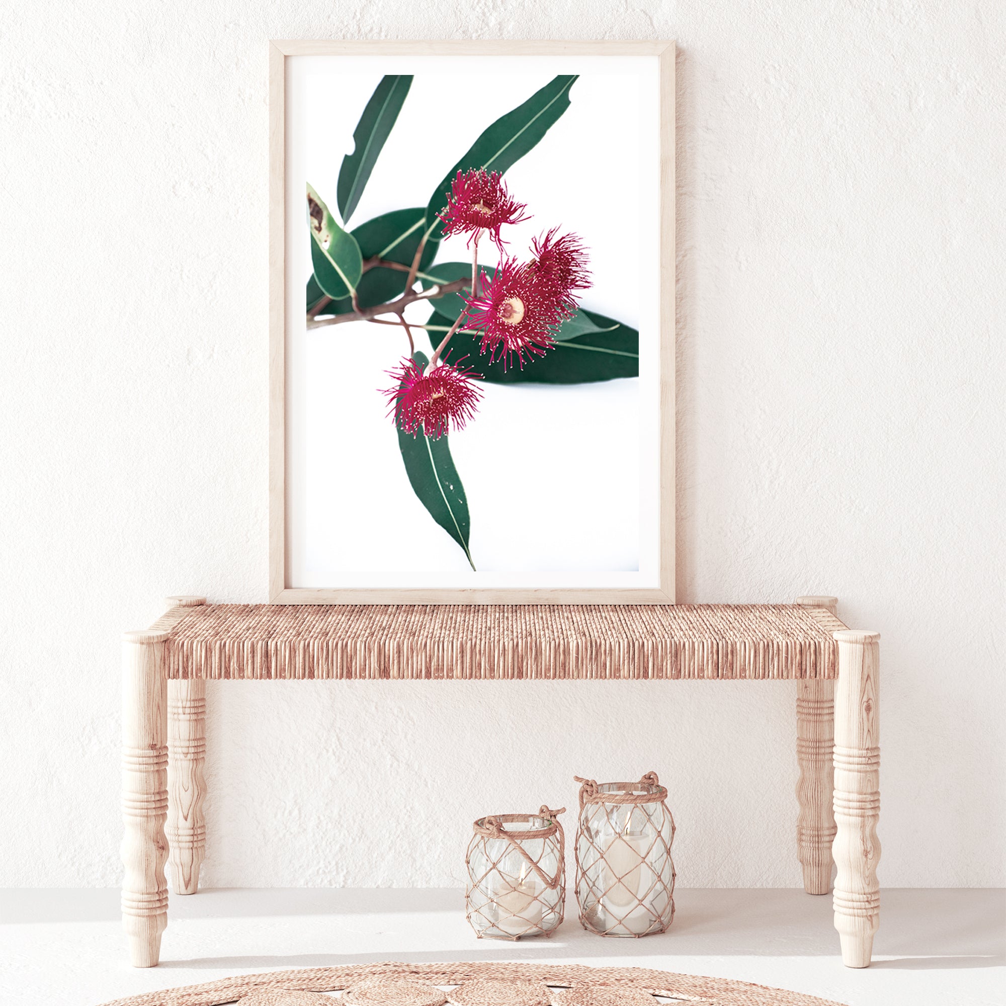 A stretched canvas floral wall art print featuring green eucalyptus leaves with beautiful red wild flowers, available framed or unframed.