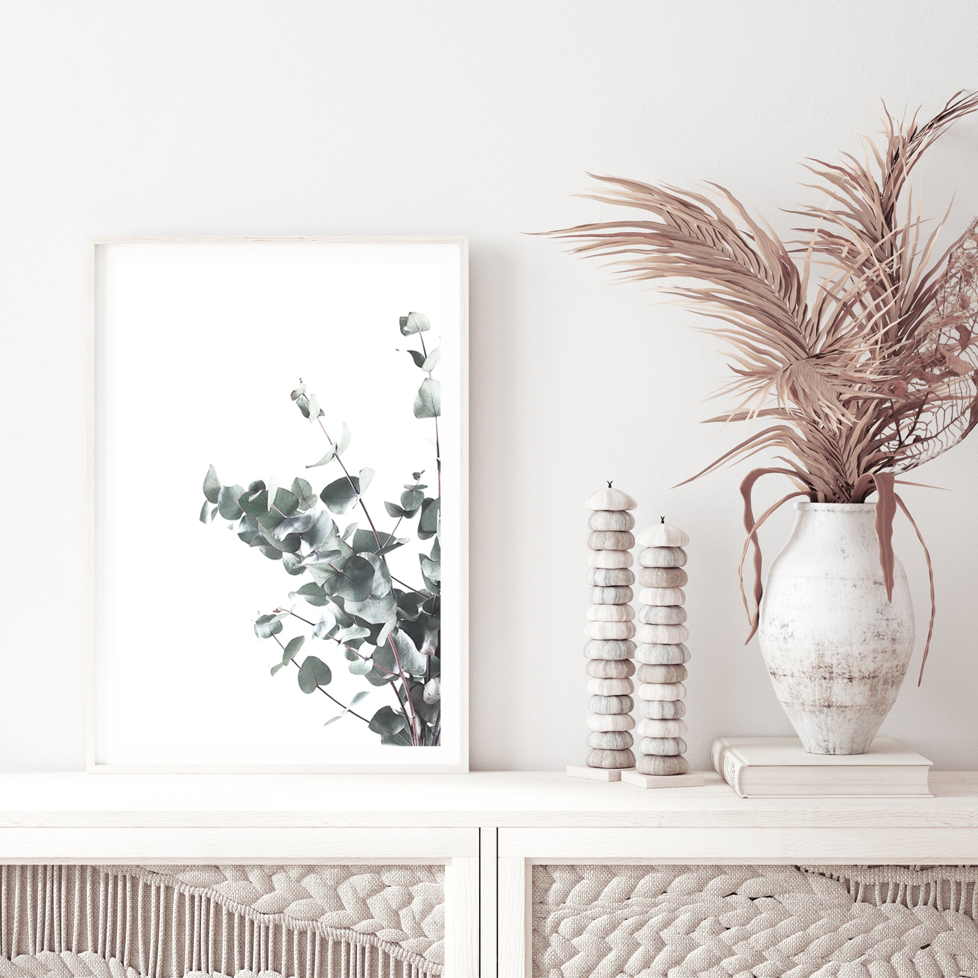 A framed or unframed artwork feauturing eucalyptus leaves (B)with a light background available as a canvas or photo print.