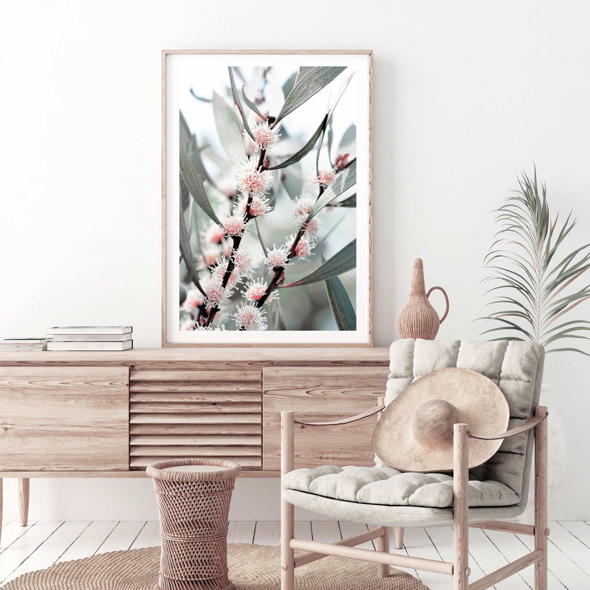 A wall art print featuring eucalytpus pink wild flowers and green leaves with branches in the background, available framed or unframed.  