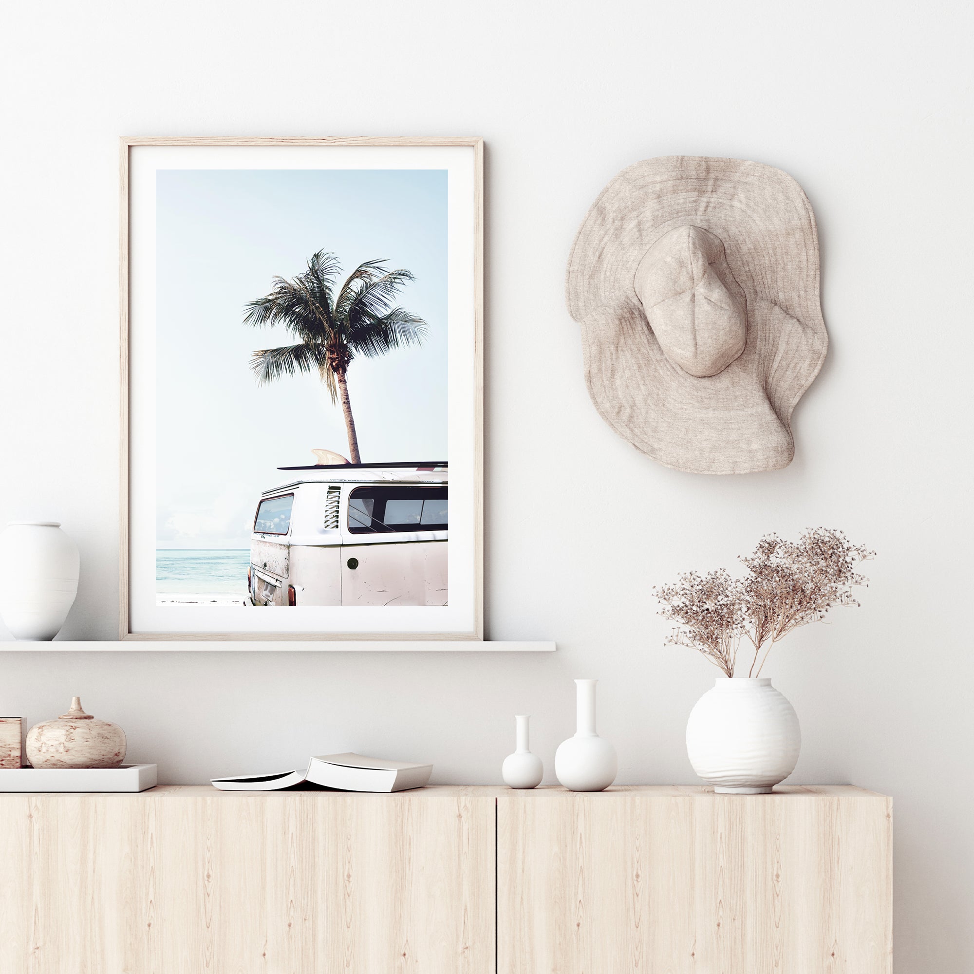 A wall art print featuring a blue Kombi van at the beach with a blue sky and palm trees, available in framed or unframed prints.