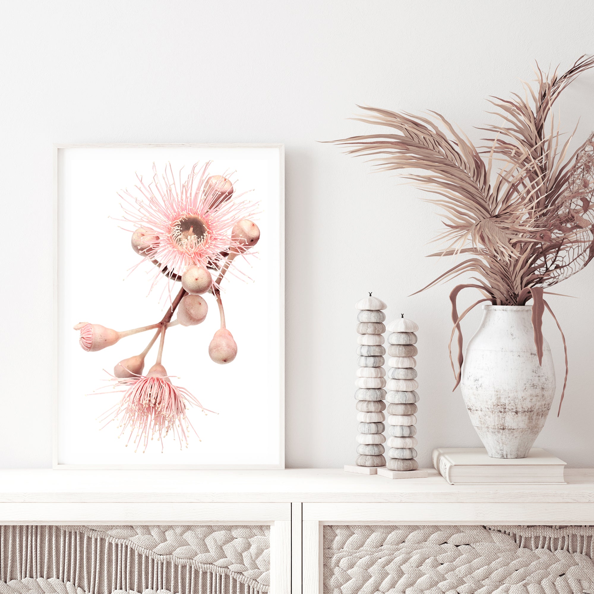 An framed or unframed Australian artwork of green leaves and pink eucalyptus wild flowers with a neutral background.