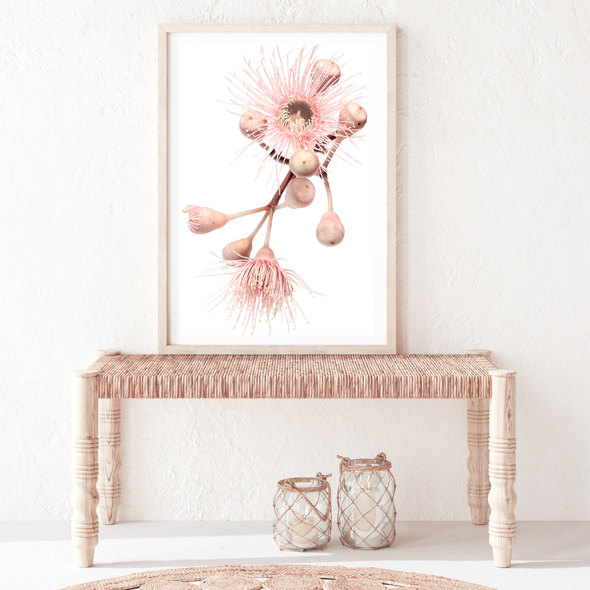 An unframed or framed nature inspired artwork of green leaves and pink eucalyptus wild flowers with a neutral background.