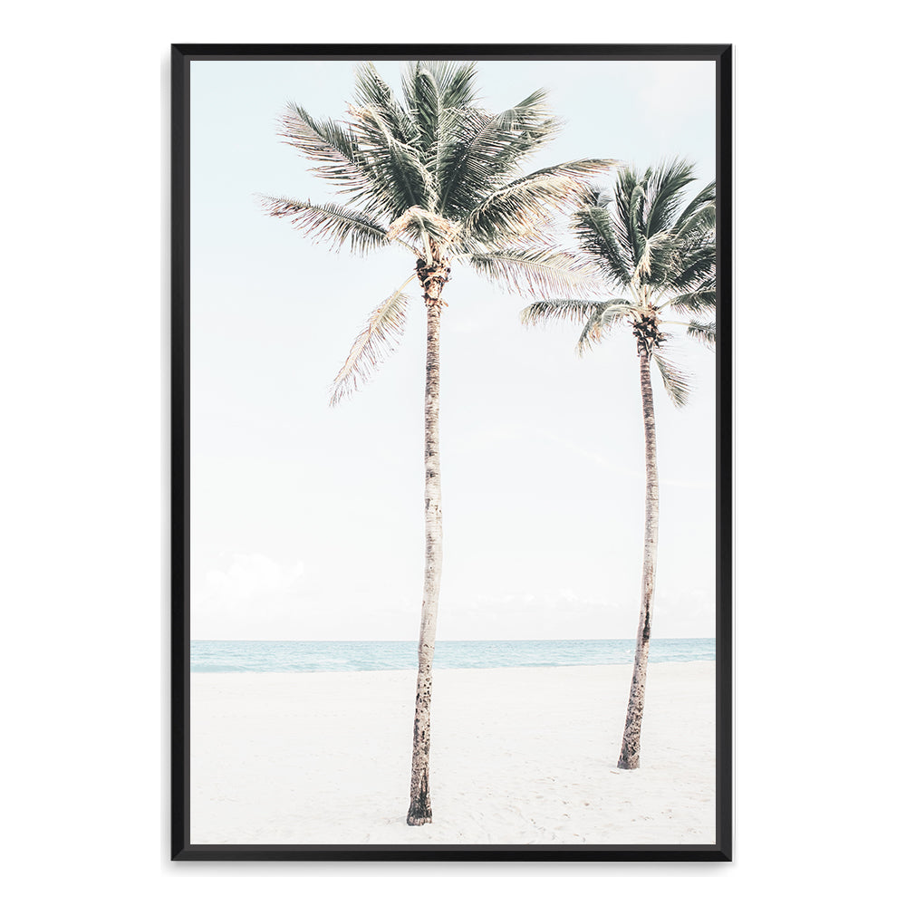 A coastal artwork of two palm trees, blue skies and the beach, available framed or unframed.