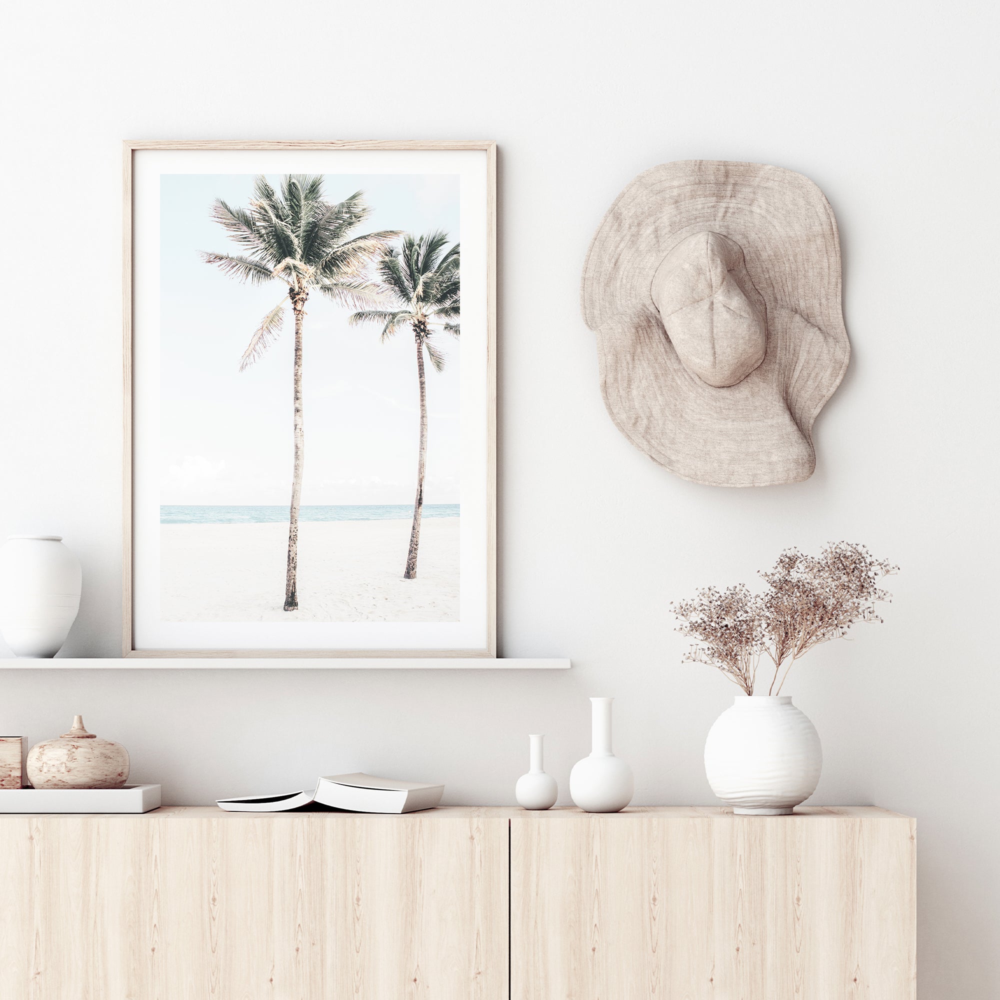 A coastal artwork of two palm trees, blue skies and the beach, available in print and canvas. 