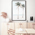 A framed or unframed stretched canvas of a coastal artwork of blue skies, two palm trees and the beach