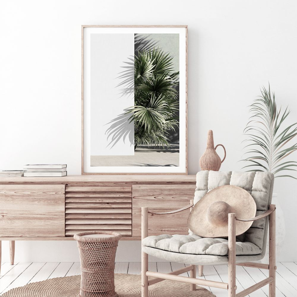 A trendy framed or unframed artwork of vibrant green palm fronds against a white wall, available in canvas or print. 