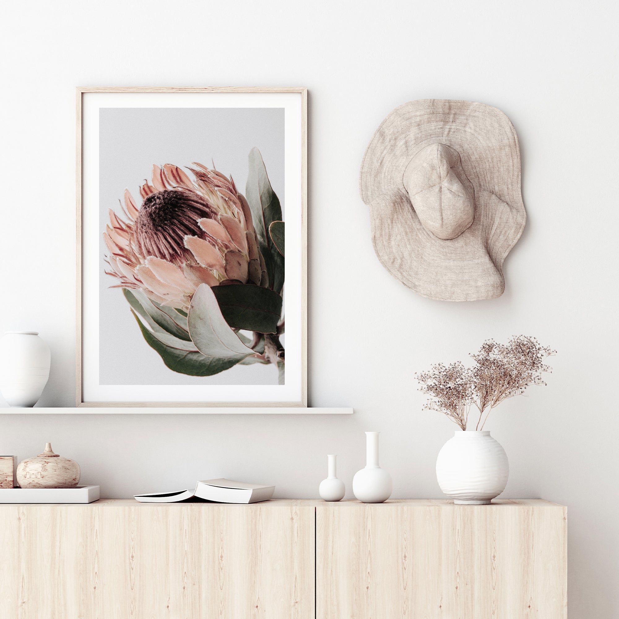 A beautiful floral artwork featuring 1 peach protea flower with green leaves in muted tones in an unframed or framed print. 