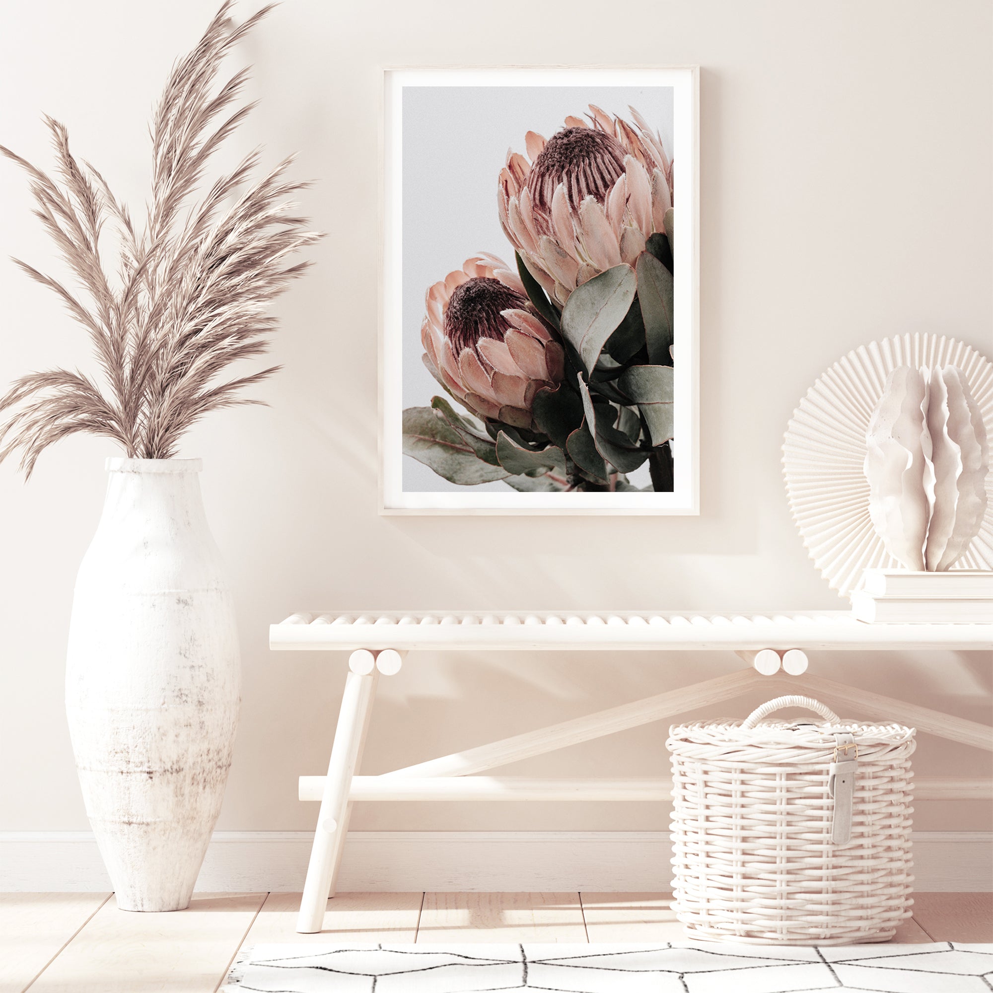 A wall art print featuring two beautiful peach protea flowers with green leaves in muted tones, available unframed or framed.