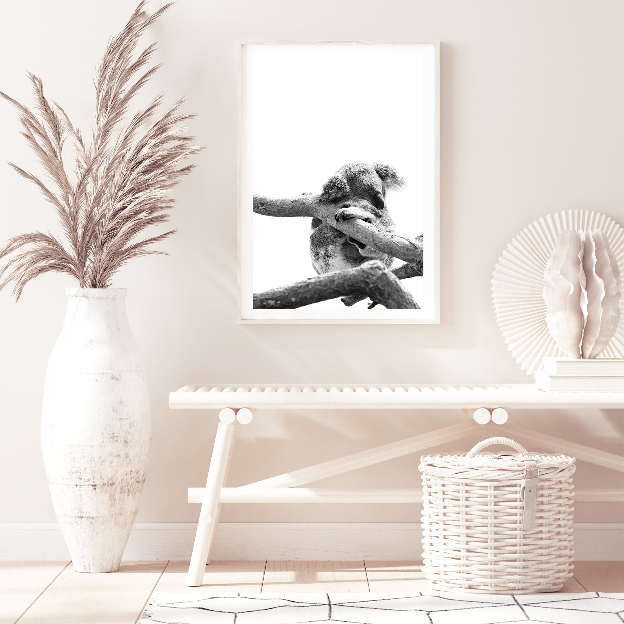 A gorgeous wall art print of a sleeping koala in a tree on a white background, available unframed or with a timber, black or white frame.