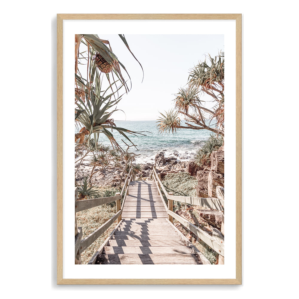 A coastal artwork of stairs leading onto a beach with beautiful blues of the sea and trees, available in print and canvas.