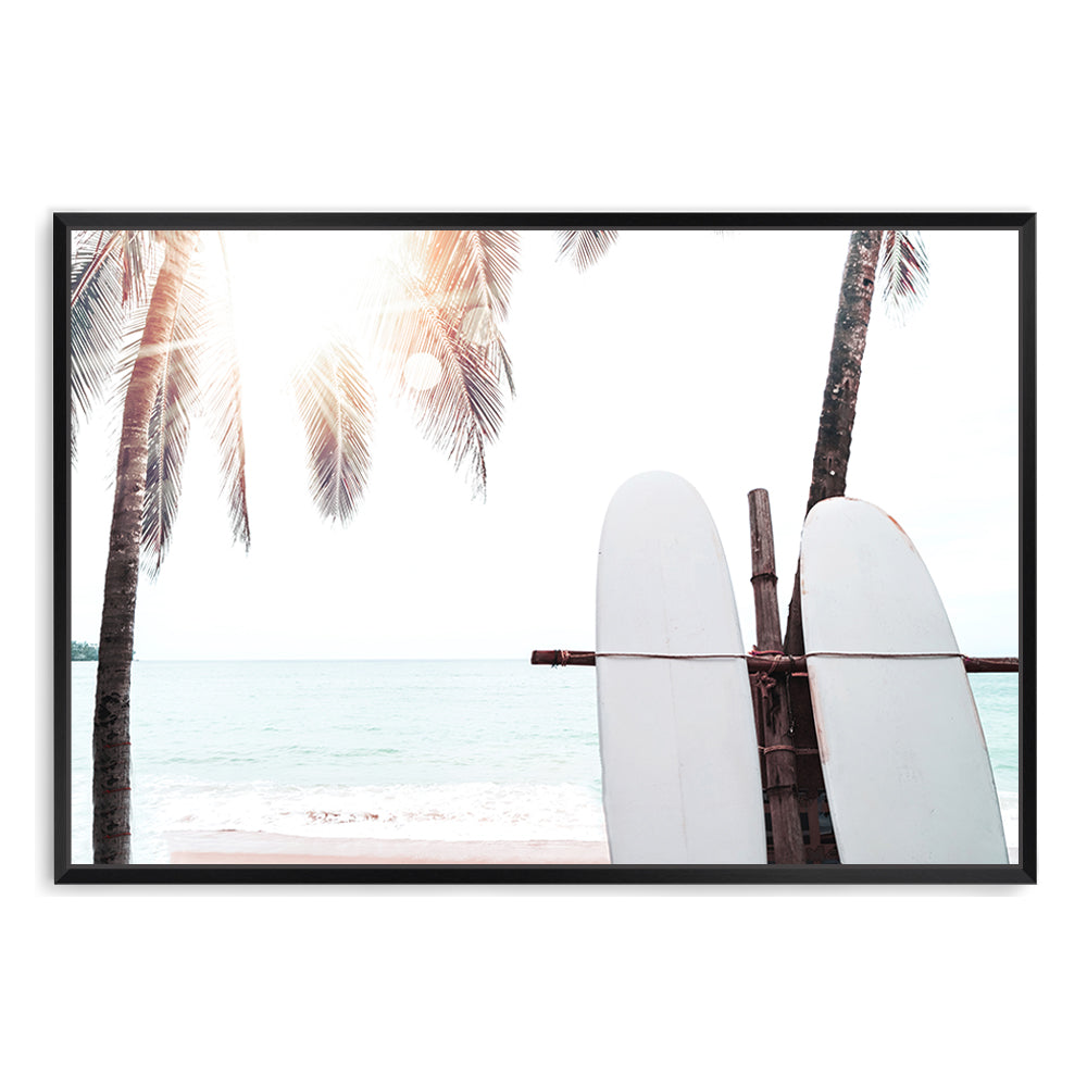 A coastal artwork featuring two white surfboards on a beach under the palm trees with a tropical sunset view.