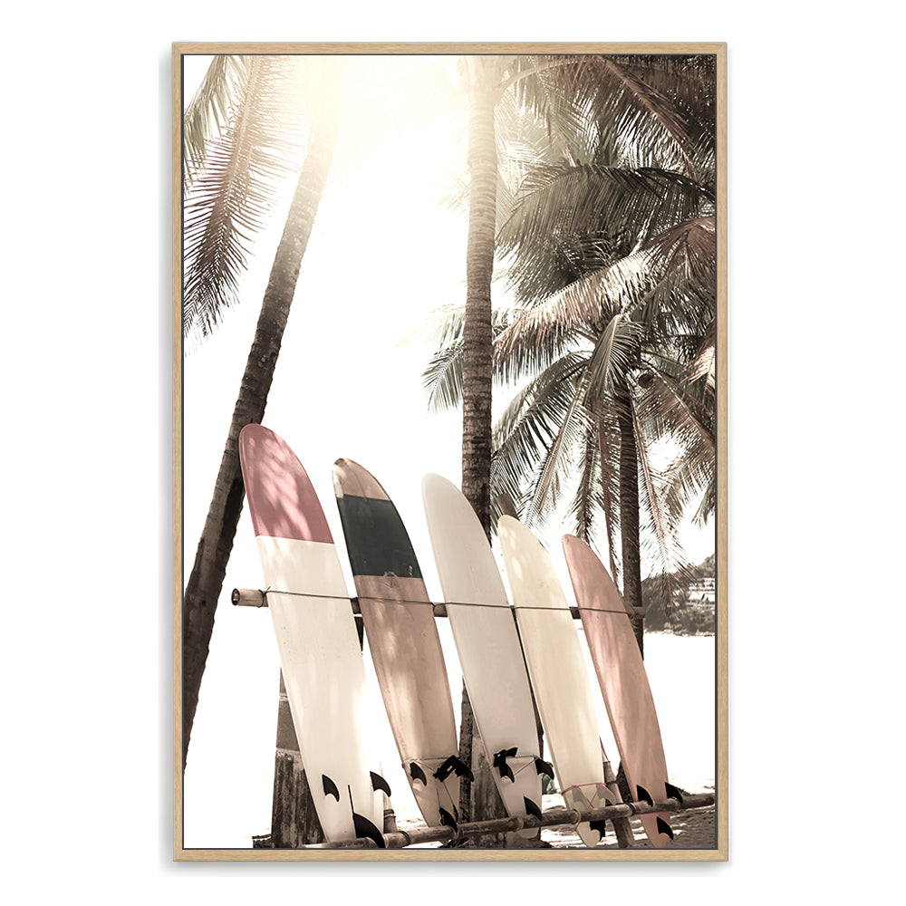 A wall art featuring four white surf boards under the palm trees on a tropical beach available in canvas or print artwork.