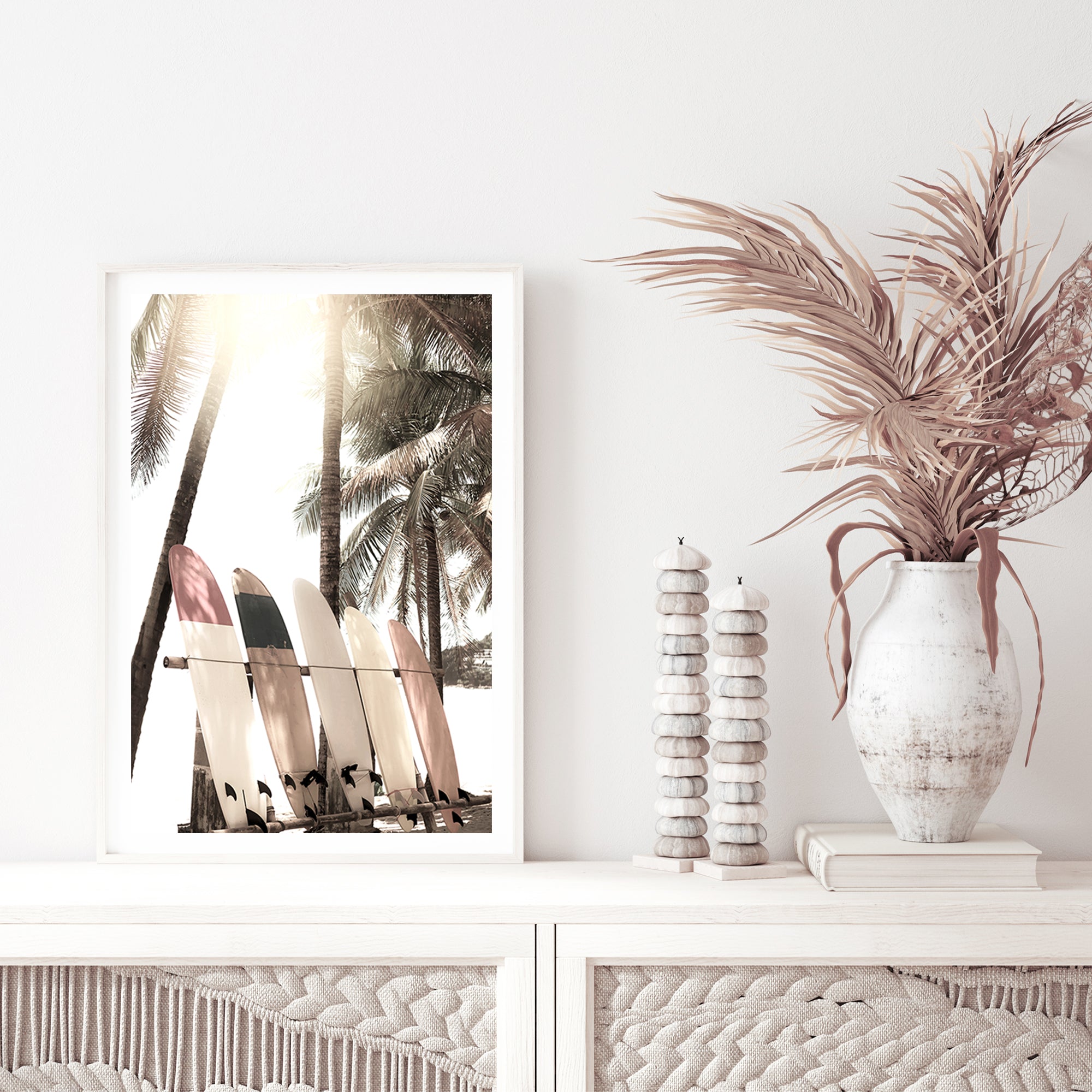 A coastal wall art featuring four white surfboards on a beach under the palm trees with a tropical sunset view.